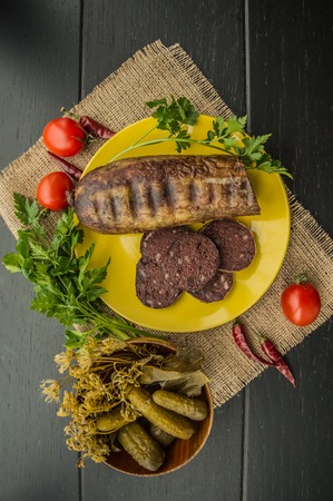 Homemade blood sausage with offal on a black wooden background. top viewの写真素材