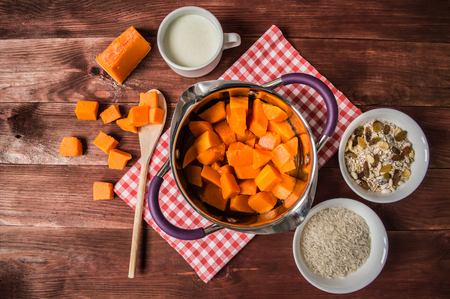 Breakfast of boiled pumpkin pieces and raisins on a rustic wooden background.の写真素材