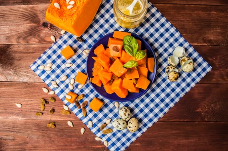 Breakfast of boiled pumpkin pieces and raisins on a rustic wooden background.の写真素材