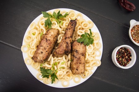 Delicious baked pork ribs with Italian pasta. Top view. Close-up