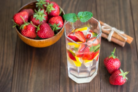 Fresh lemonade with strawberries, mint and ice on a wooden table.の写真素材