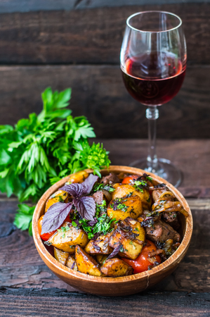 Roasted meat with potatoes, ojaxuri, hot in Georgian and red wine on a wooden table. Top viewの写真素材