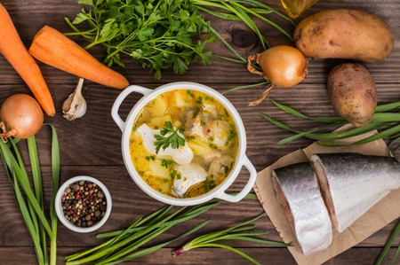 Fresh fish soup with ingredients and spices for cooking. Wooden background. Top viewの写真素材