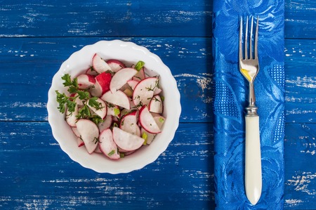 Salad with radishes, apples and greens. Blue background. Top view. Close-upの写真素材