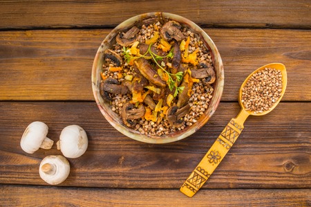 Buckwheat porridge with meat and mushrooms on wooden rustic backgroundの写真素材