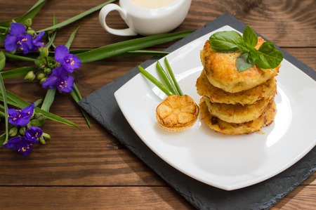 Potato pancakes with sour cream sauce on the background colorの写真素材