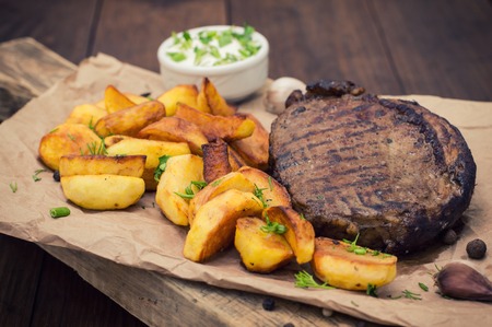grilled steak with fried potatoes. Wooden background. Top view. Close-upの写真素材