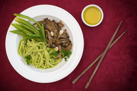 Plate of spaghetti dough with spinach and oyster mushrooms. Italian cuisine, Italian recipes