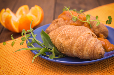 Orange jam and croissants for breakfast. Wooden background. Top viewの写真素材