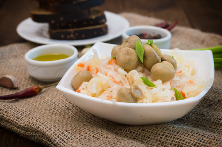 Braised cabbage with carrots and mushrooms in a bowlの写真素材