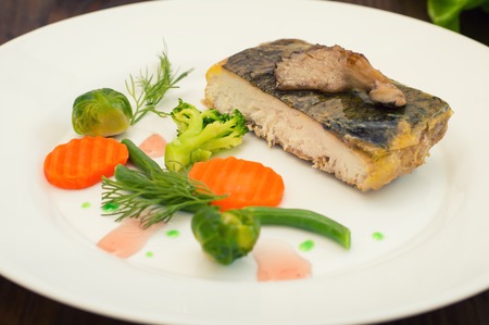 Tasty baked fish on plate on table close-upの写真素材