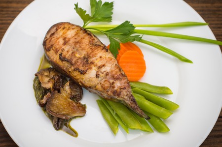 Tasty baked fish on plate on table close-upの写真素材