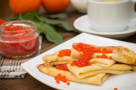 Pancakes with red caviar. Russian cuisine. Flat lay. Maslenitsa. Wooden backgroundの写真素材