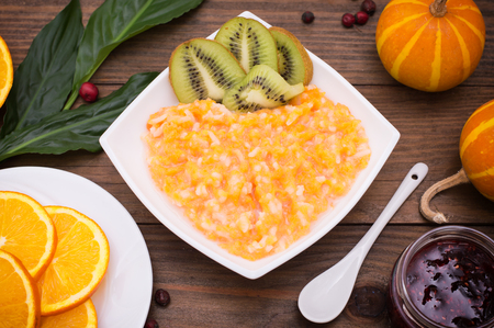 Pumpkin porridge with fruit. Autumn still-life. A rustic style. Wooden backgroundの写真素材