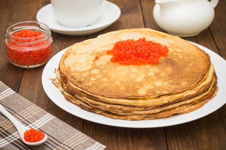 Pancakes with red caviar. Russian cuisine. Flat lay. Maslenitsa. Wooden backgroundの写真素材