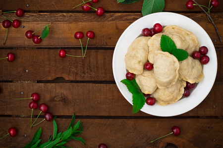 Homemade dumplings with cherries. Wooden rustic background. Top view. Close-upの写真素材