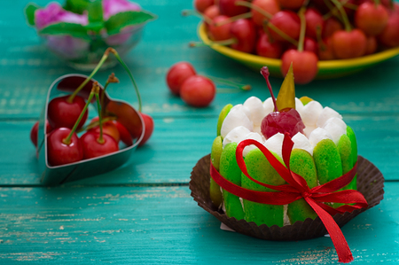 Creamy cake with cherries. Wooden turquoise background. Close-up. Top viewの写真素材