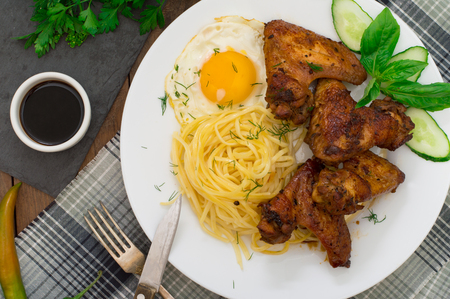 Fried chicken wings with spaghetti. Wooden background. Top view. Close-upの写真素材