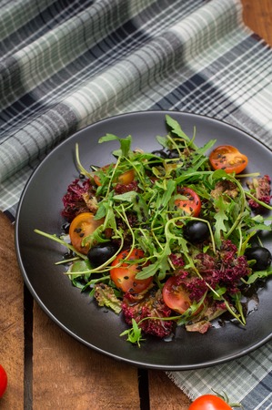 Fresh salad with arugula, shrimp, cherry tomato and avocado. Wooden background. Top view. Close-upの写真素材