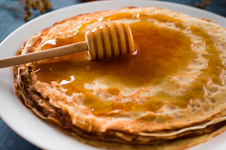 Fresh pancakes with honey, maple syrup, cottage cheese and tangerines. Wooden background. Top view. Selective focusの写真素材