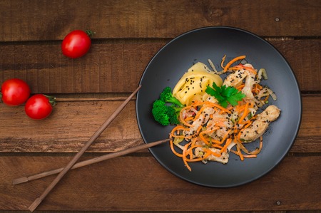 Fresh Chicken salad with Korean carrots, cauliflower, cheese and green vegetables. Healthy food concept. Wooden rustic background. Top view.の写真素材