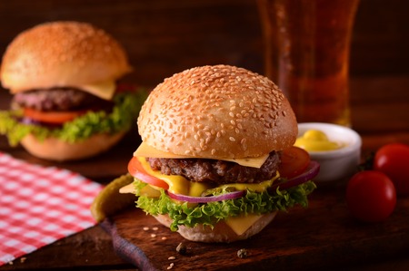 Fresh burger closeup and beer. Wooden rustic background, top viewの写真素材