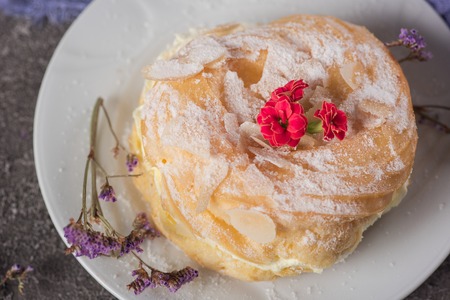 Delicious cake with cream on a plate. Concrete rustic background. Top view.