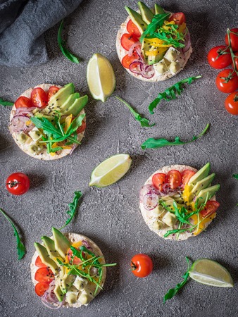 Bruschetta with tomato, avocado, herbs and arugula. Rustic backgroundの写真素材