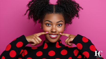 Young african american woman in polka dot blouse on pink backgroundの素材