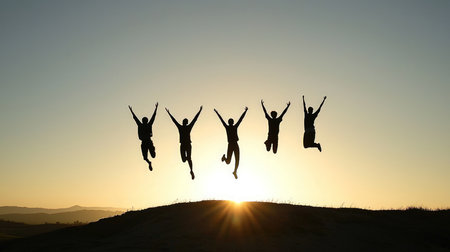 Silhouette of a group of people jumping in the air.の素材
