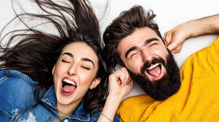 young couple of pretty woman with long brunette hair and handsome bearded man with beard on smiling face lying on white backgroundの素材