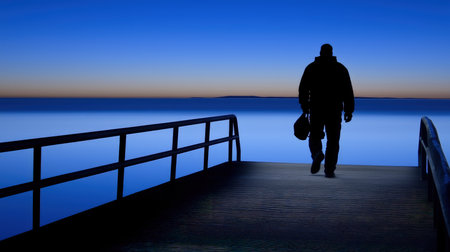 Silhouette of a man with a suitcase on the pier.の素材