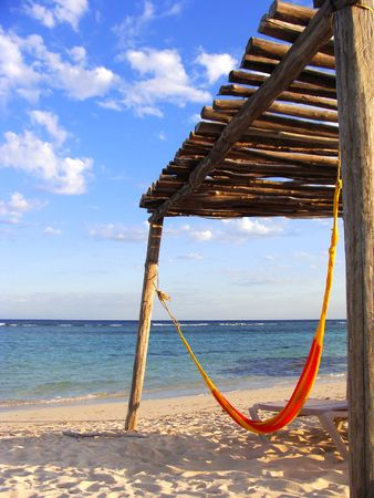 Orange hammock on a warm beach in the mexican caribbeanの写真素材