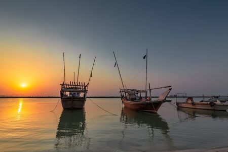 Beautiful Sunrise Boat in seaside with yellow and blue sky background. Dammam -Saudi Arabiaの写真素材