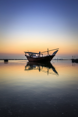 Beautiful Sunrise Boat in seaside with yellow sky. Dammam -Saudi Arabiaのeditorial素材