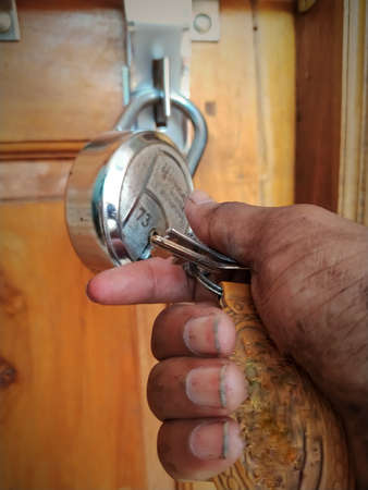 Worker open unlock the door lock with holding in key in dirty handの写真素材