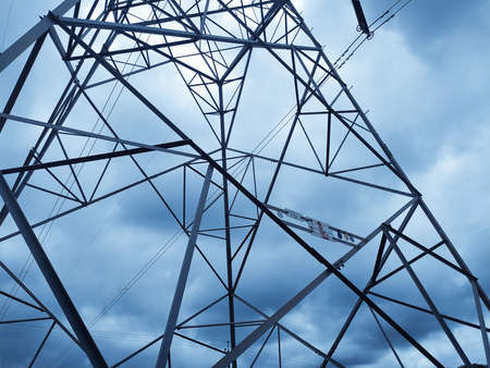 Metallic truss of electric power transmission tower in cloudy sky