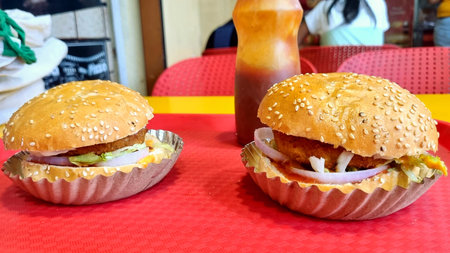 Two hamburgers on a red tablecloth in a fast food restaurantの写真素材