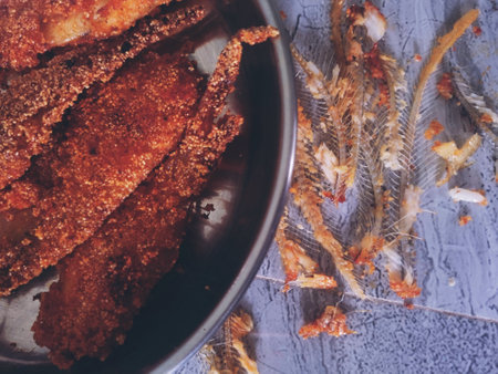Fried fish on a plate on a wooden background. Top view