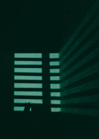 Moonlight overlay on blue aqua color wall through striped window seems cat shadow in monochromatic imageの写真素材