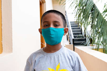Kalaburagi, Karnataka/India-June 13 2020: an Indian boy wearing face mask for covid-19 virus protection background buildingのeditorial素材