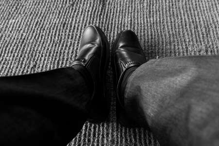 a closeup shot of wearing black shoes isolated on textured mat