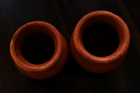 a top view of handmade little clay pots isolated on brown table