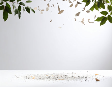 Wooden table with ash and falling leaves on white background, space for textの素材