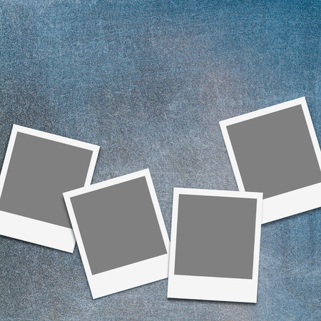 Four blank instant photo frames on scratched, old chalkboard; Set of empty snap shot frames on blew-gray backgroundの写真素材