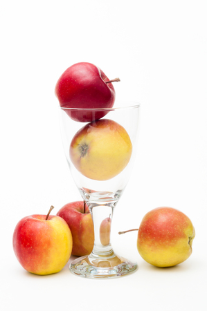 Crispy red-yellow apples Arranged with drinking glass against white background; Apple juice; Natural healthy fitness drink; Fruit juiceの写真素材