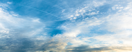 Panoramic view of overcast sky with cirrostratus clouds and condensation trails; Cloud formation at blue skyの写真素材