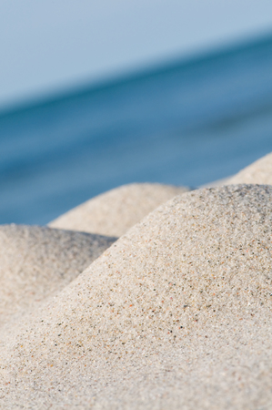 Small hills of fine white sand on the beach against horizon over the blue ocean; Maritime...