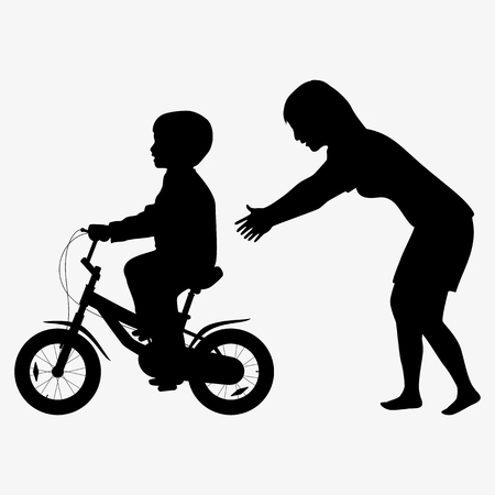 Mother teaches a child to ride a bike silhouetteの写真素材