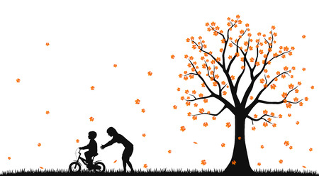 Mother teaches a child to ride a bike in the autumn parkの写真素材